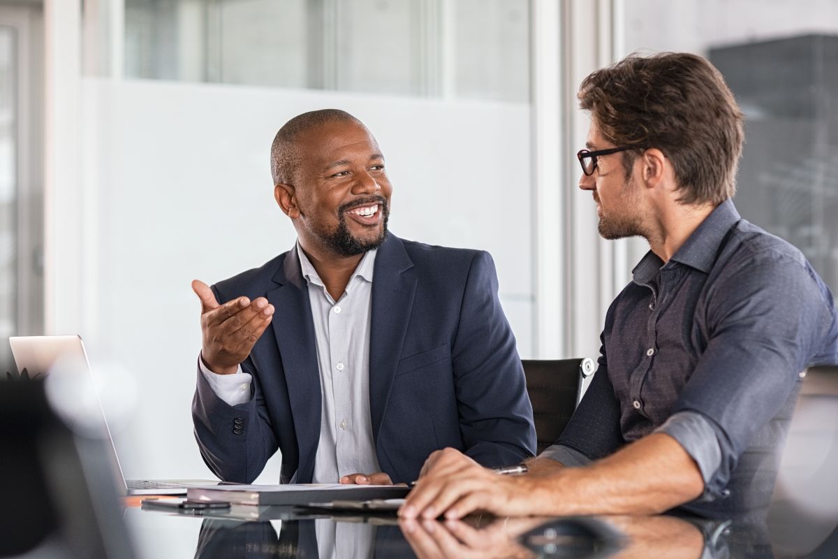 Personal growth coach engaging in a one-on-one discussion with a client in a modern office, offering guidance and support for personal and professional development.